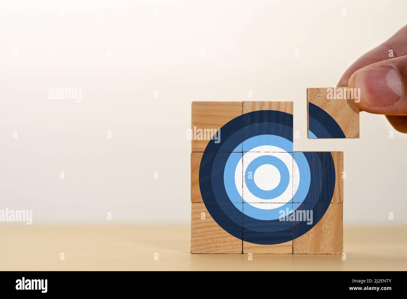 Hand setzen Holzblock zu Dartscheibe zu machen. Konzept der Zielbewertung oder Festlegung eines Ziels. Stockfoto