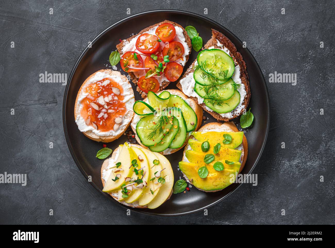 Crostini mit Feta, Ricotta und verschiedenen Gemüse und Früchten. Stockfoto