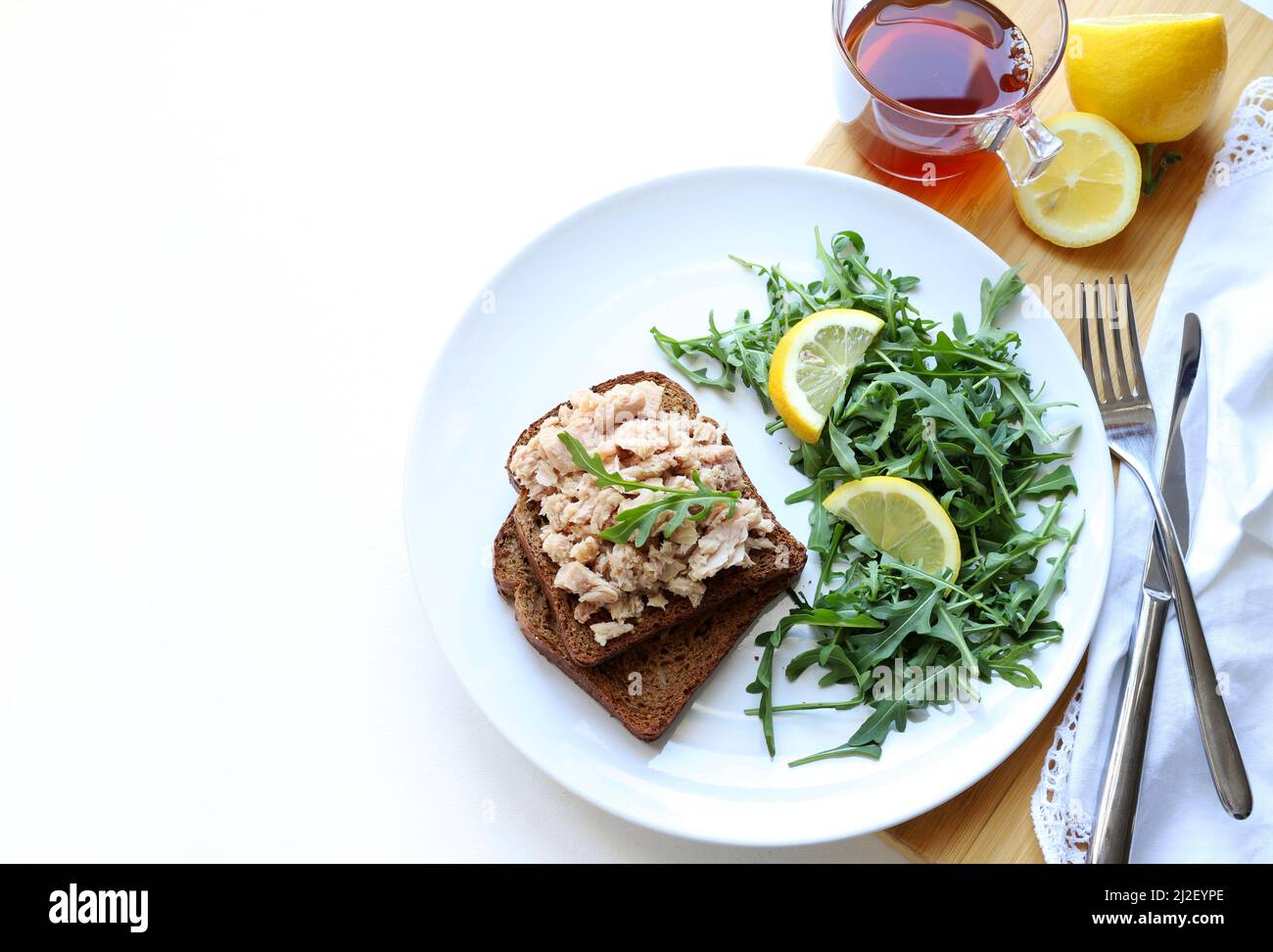 Scheiben Vollkornbrot mit Thunfisch, Zitrone und Gemüse isoliert auf weißem Hintergrund. Thunfisch-Vorspeise. Direkt darüber. Stockfoto