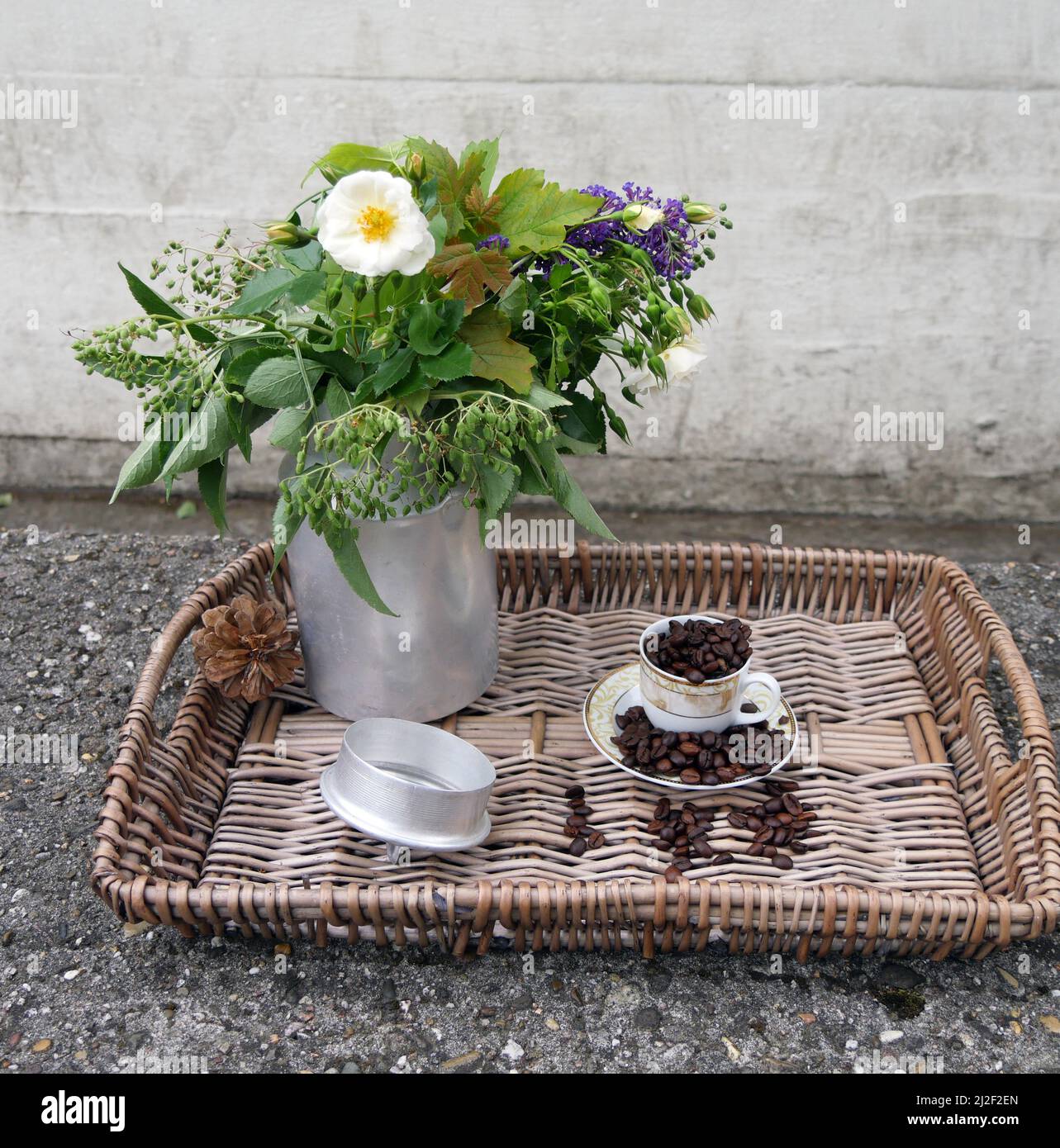 Stillleben Eines Tabletts mit Blumenstrauß und Kaffeebohnen auf dem Steintisch Stockfoto