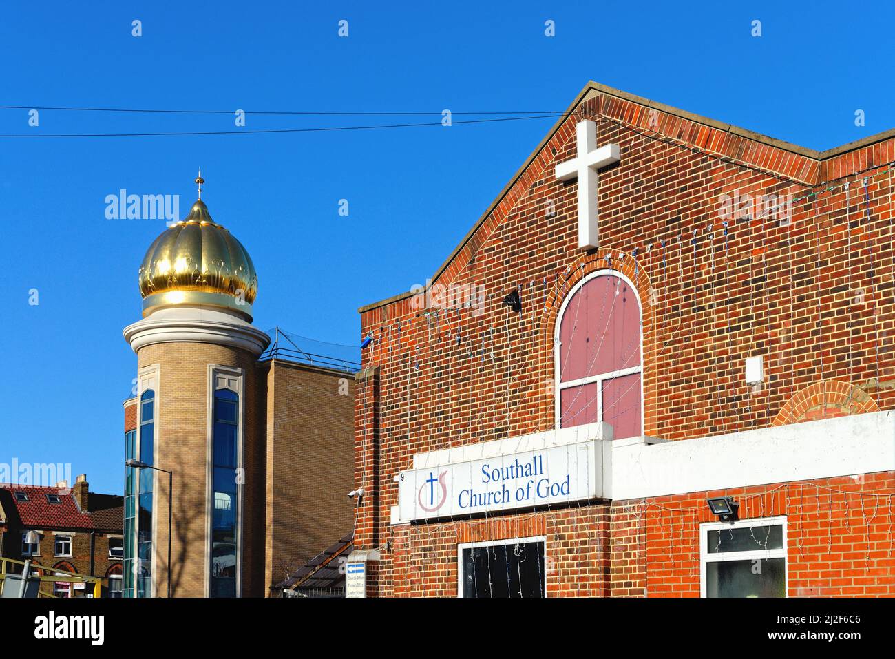 Der Gurdwara Guru Nanak Darber Sikh Tempel und die Southall Church of God Gebäude nebeneinander in Southall West London England Stockfoto