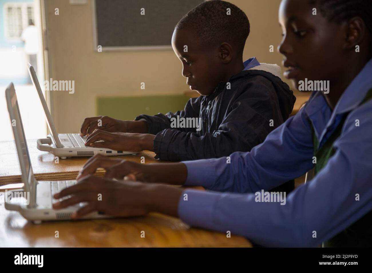 Die Schüler Moses Wilinge (13, l) und Irena Nghidengwa (13, r) lernen mit neuen Laptops an der Shikudule Combined School in der Region Oshana, Namibia. Als Teil o Stockfoto