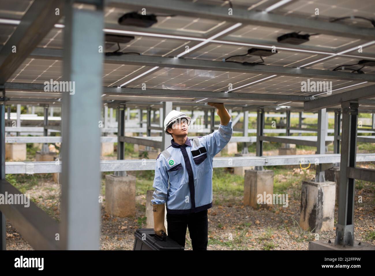 Ein Elektrotechniker betreibt Ausrüstung in einem Solarkraftwerk auf der Insel Karampuang, Indonesien, Asien. Stockfoto