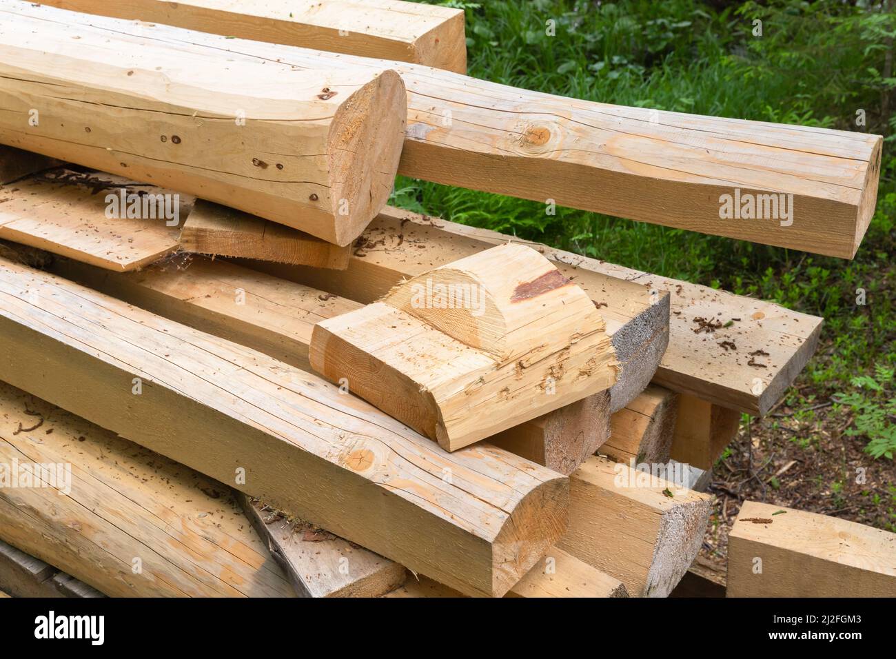 Holzbretter und Rundholz, gestapeltes Holz für den ländlichen Bau, aus nächster Nähe Stockfoto