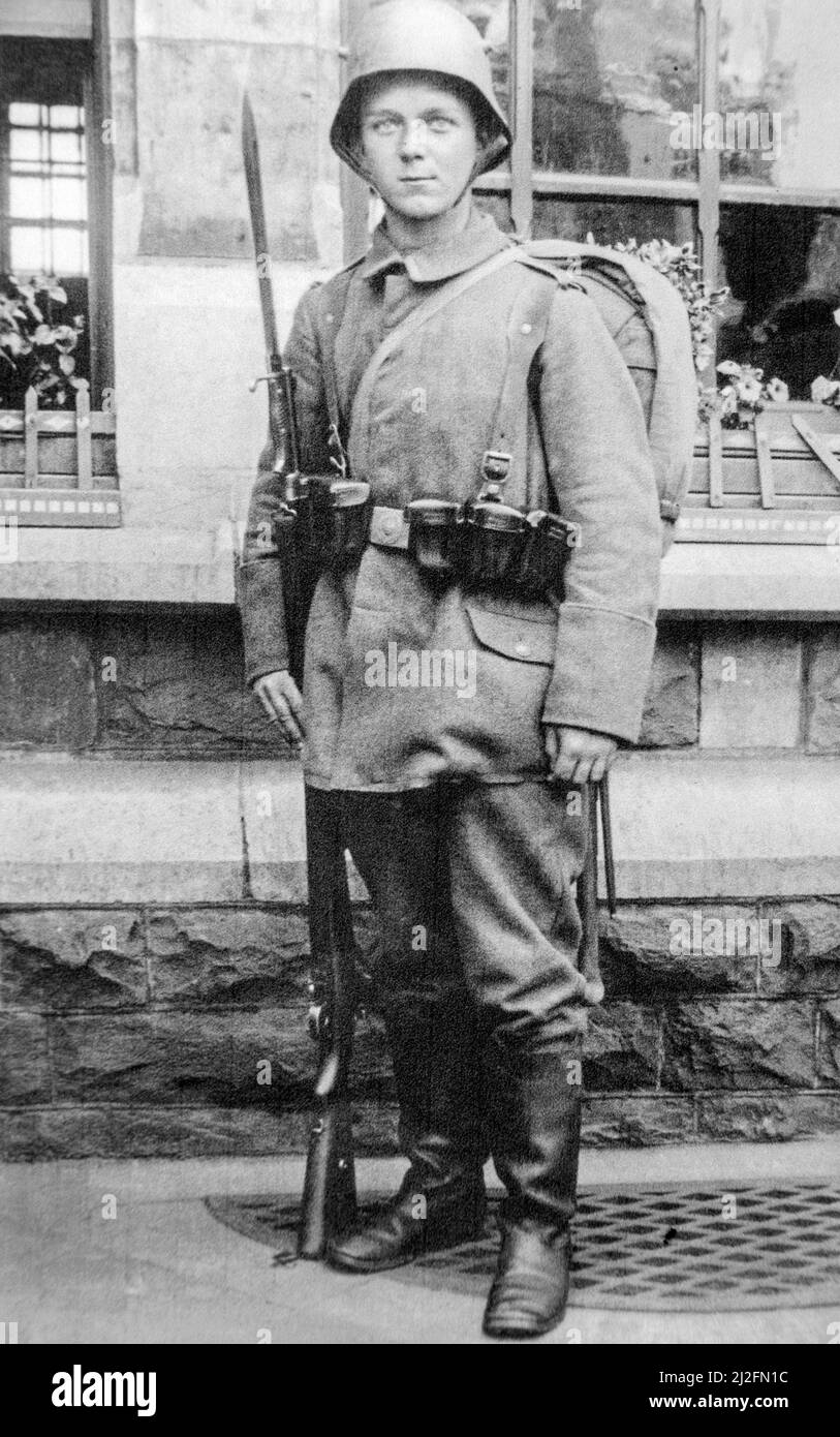 Junger deutscher bayerischer Infanteriesoldat / Infanterist, der 1917 während des Ersten Weltkriegs im Kampfkleid mit Gewehr, Bajonett und stahlhelm posiert Stockfoto