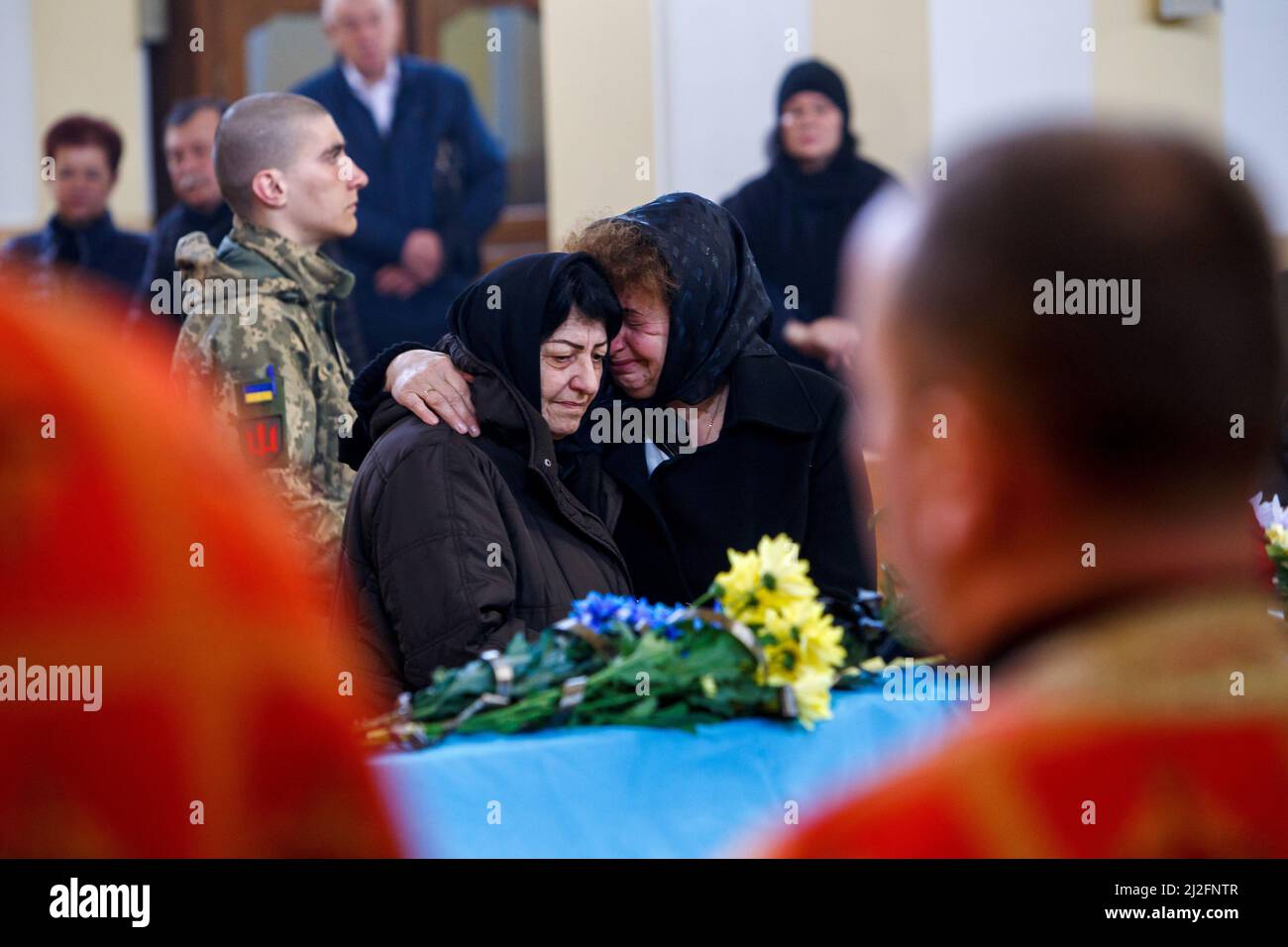 Nicht exklusiv: MUKACHEVO, UKRAINE - 1. APRIL 2022 - Frauen reagieren auf den Sarg des 18-jährigen Viktor Karytschak, einem Soldaten des mechanisierten Bataillons von Stockfoto