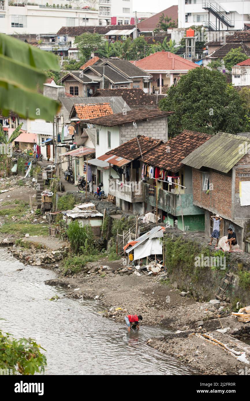 In Yogyakarta (Jogjakarta), der zweitgrößten Stadt Indonesiens, befinden sich überfüllte, farbenfrohe Slumhäuser an einem Abwasserabfluss-Kanal. Stockfoto