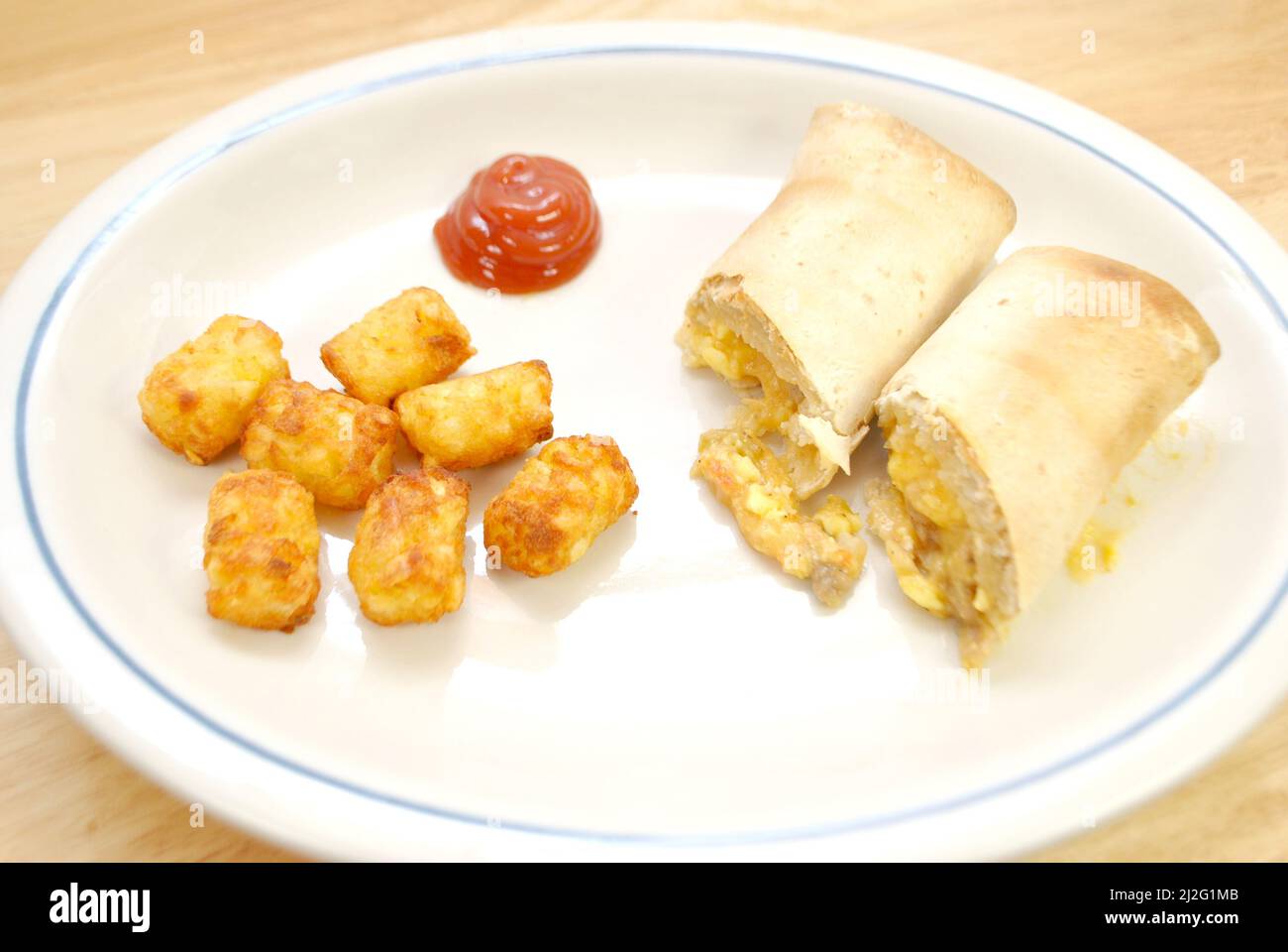 Frühstück Burrito und Tater Tots als schnelle Mahlzeit Stockfoto