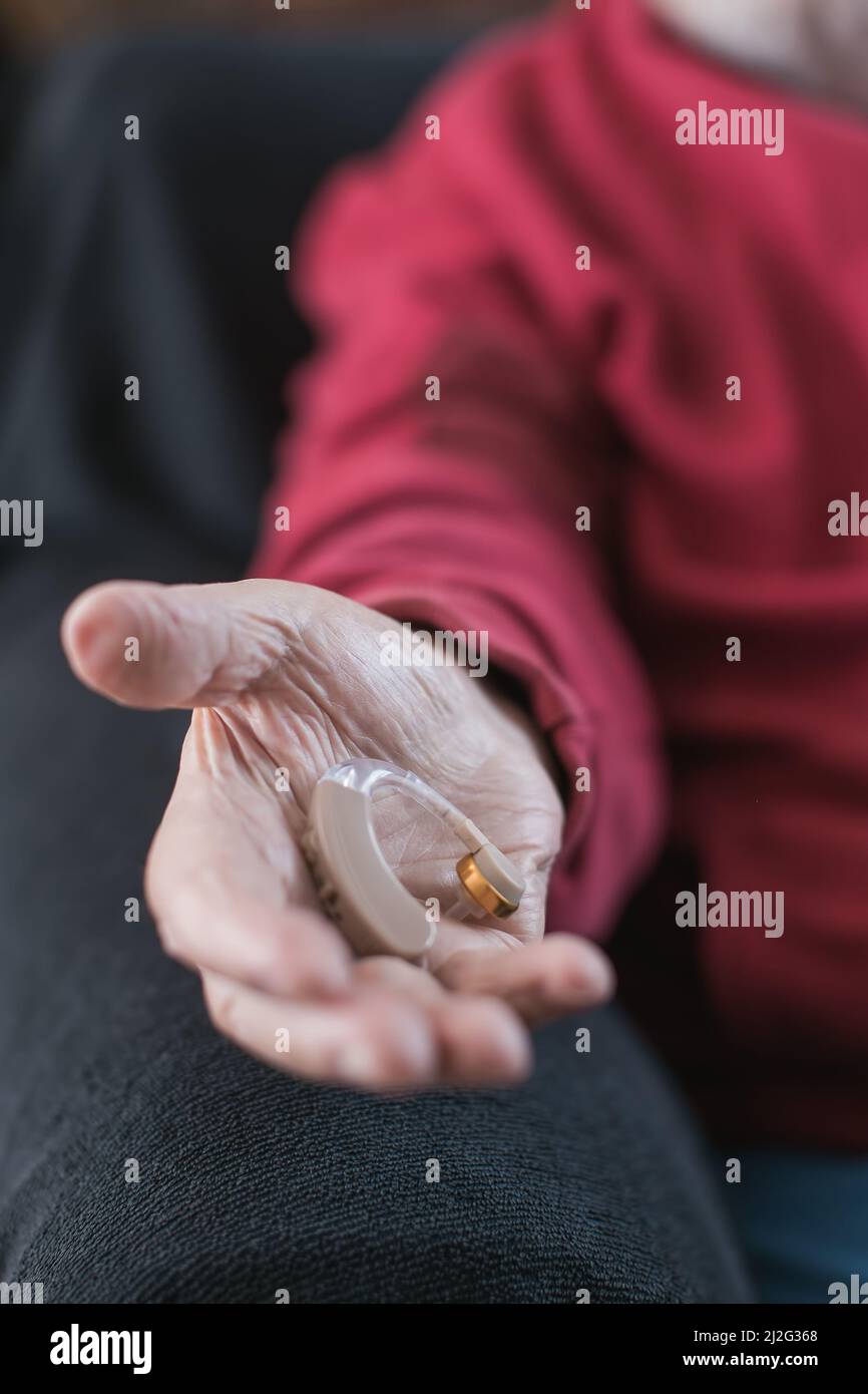Hörgerät in der Hand älterer Menschen Stockfoto