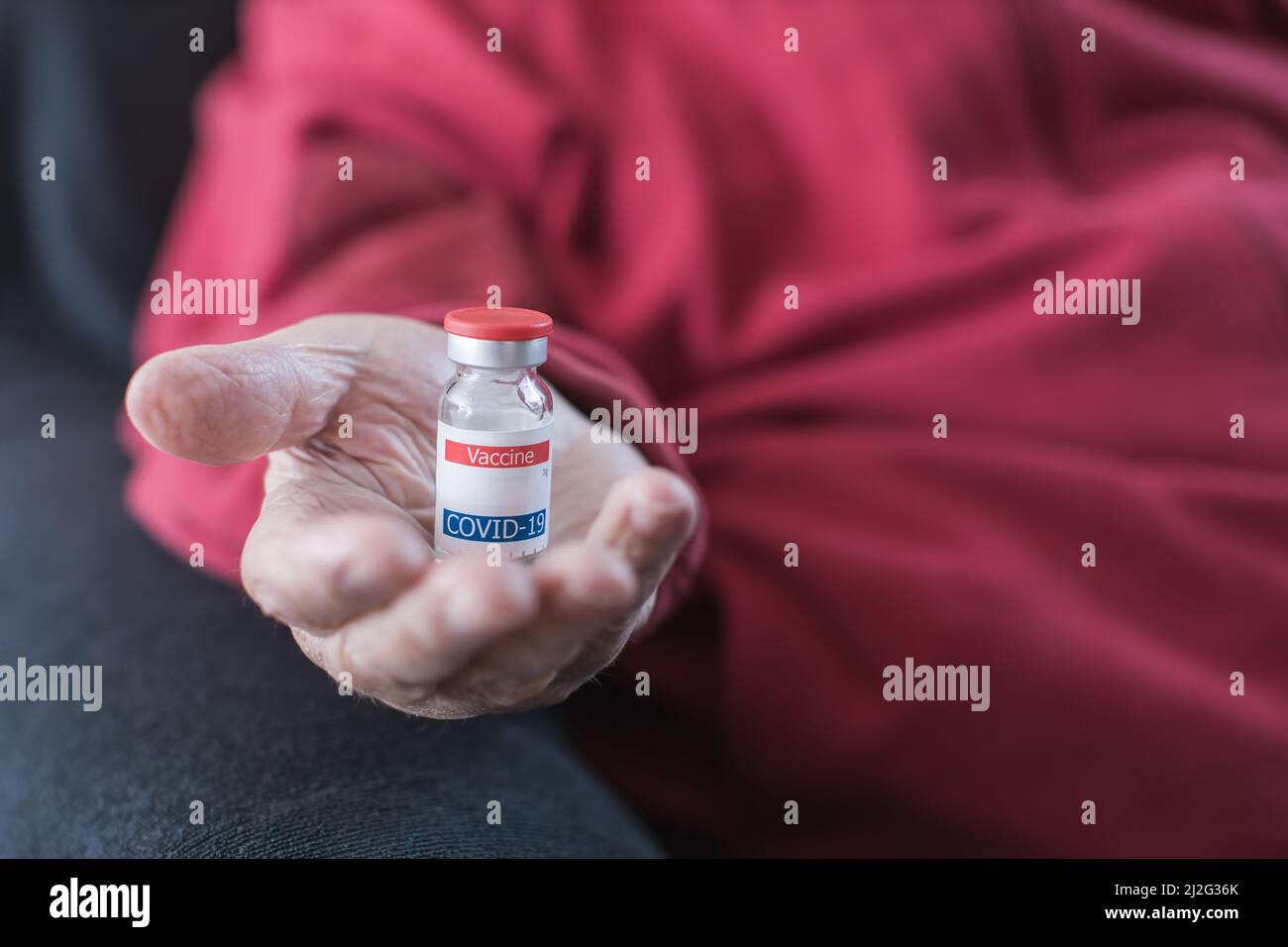 Ältere Person Hand hält Coronavirus-Impfstoff Fläschchen Stockfoto