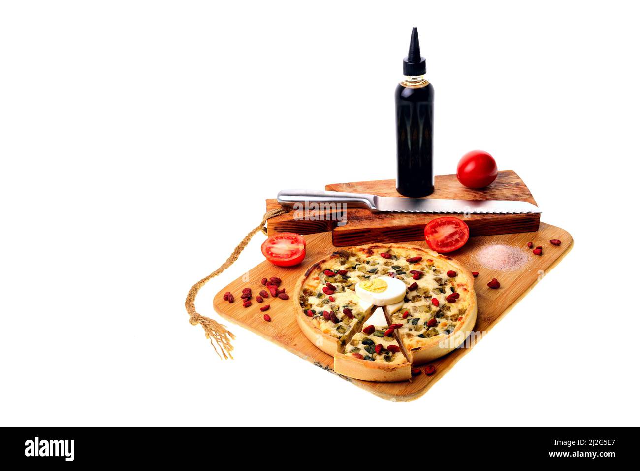 Pizza auf einem Schneidebrett mit einem Brotmesser. Tomaten, Sauce, Ei. Stockfoto