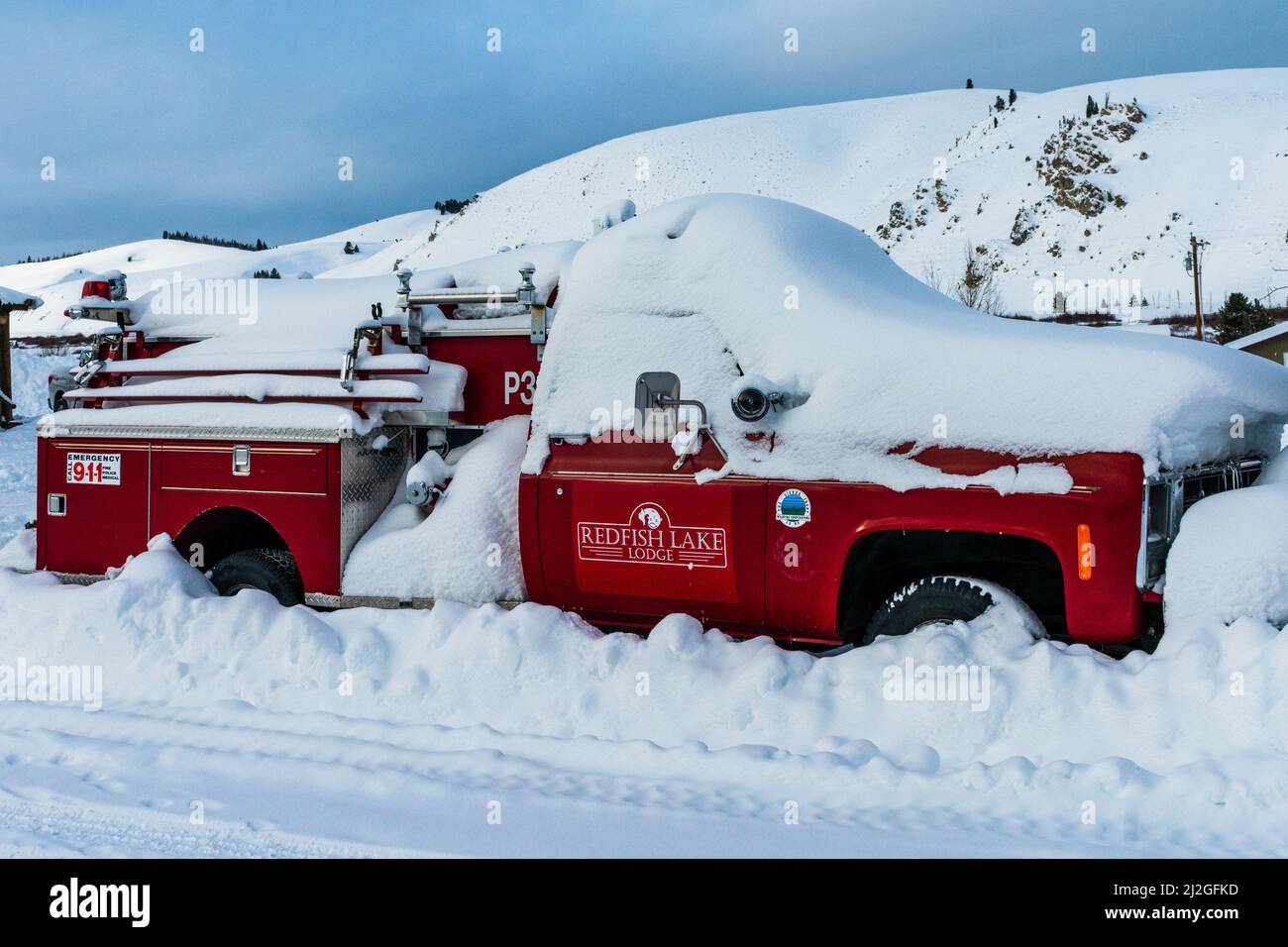 Stanley, ID USA - 28 Dec 2021: Feuerwehrauto der Red Fish Lake Lodge, vergraben im Schnee in den Triangle C Cabins Stockfoto