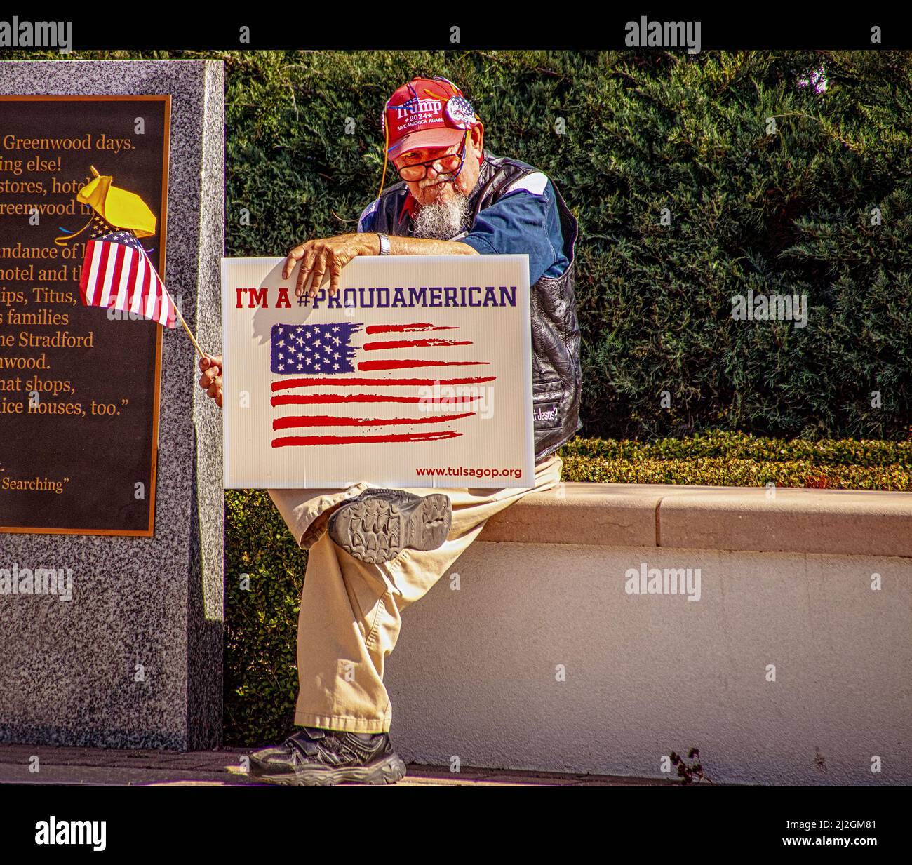 2022 )3 05 Tulsa OK USA - Senior man mit Trump-Hut und GOP-Schild sitzt mit US- und ukrainischen Flaggen im Reconciliation Park bei der pro-ukrainischen Kundgebung Stockfoto