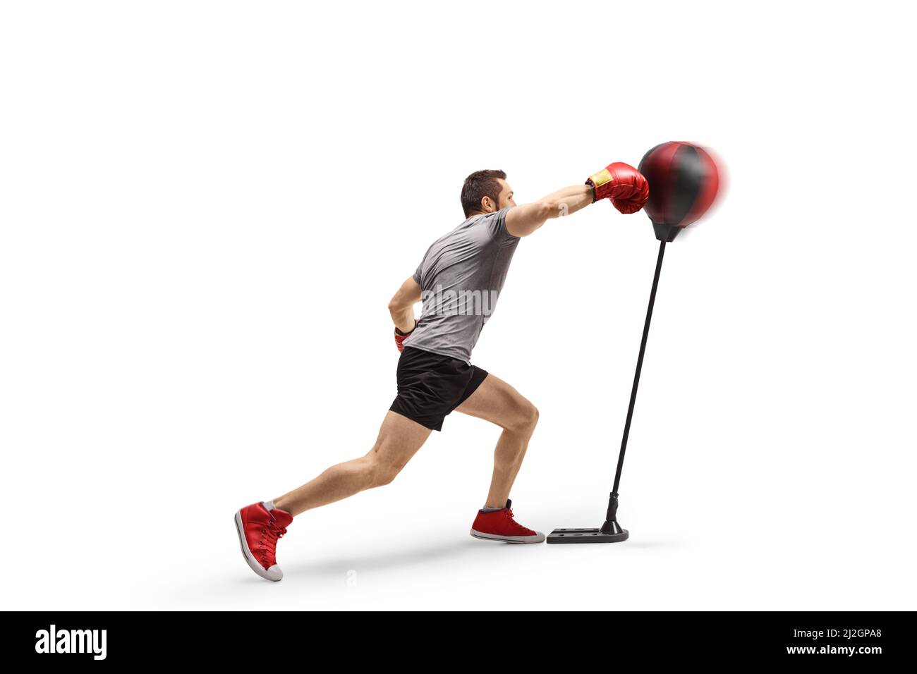 Athlet stanzt einen freistehenden Boxsack isoliert auf weißem Hintergrund Stockfoto