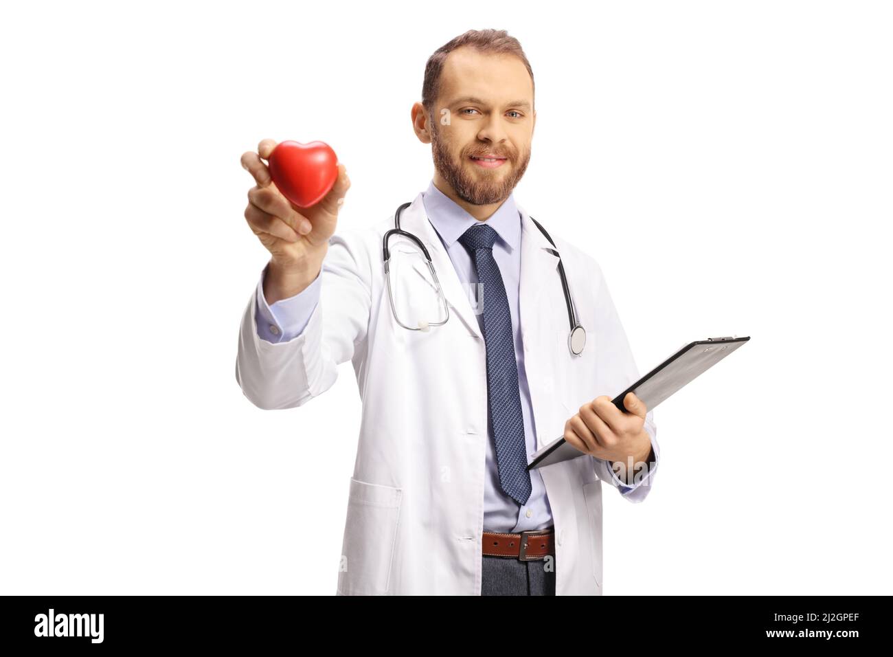 Junger Kardiologe mit einem roten Herzen und Blick auf die Kamera isoliert auf weißem Hintergrund Stockfoto