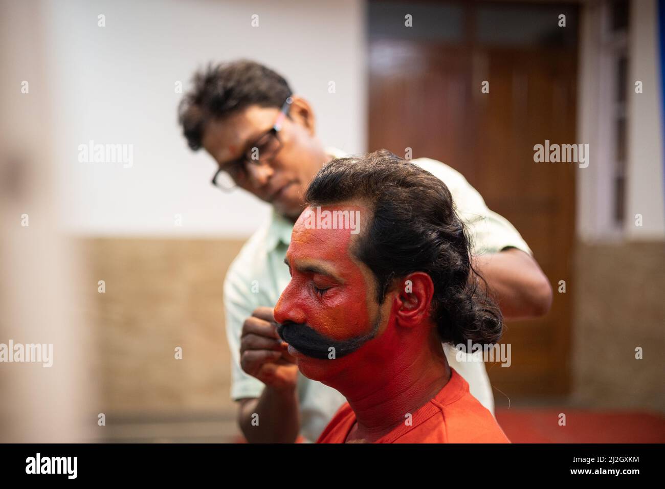 Face Makeover Künstler Befestigung gefälschte Schnurrbart auf Gesicht des Menschen soll die Rolle der Virabhadra für die jährliche Volkstanzvorstellung in Goa spielen Stockfoto