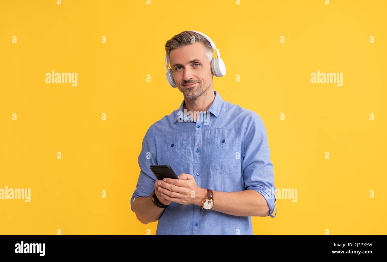 Mobile Musik-Anwendung. Neue App. Kerl in Kopfhörer Chat auf dem Smartphone. Stockfoto