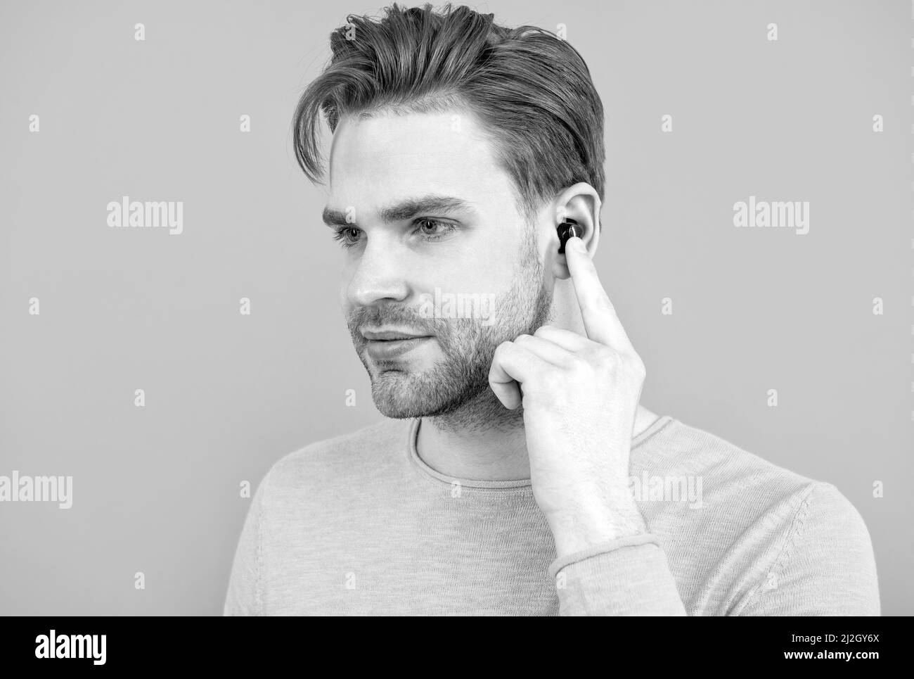 Bluetooth-Headset-Zubehör. Neue bluetooth-Technologie. Mann mit dem Finger auf den kabellosen Ohrstöpsel zeigen Stockfoto