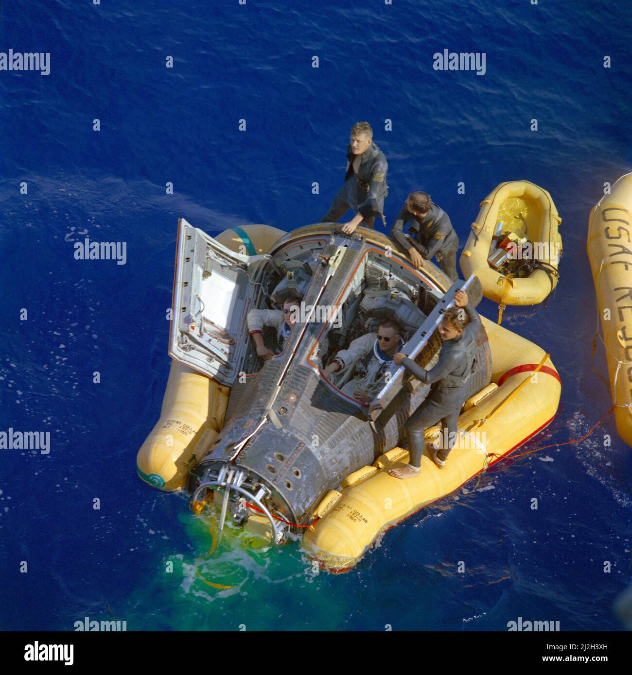 Die Astronauten Neil Armstrong (rechts) und David Scott (links) sitzen mit offenen Raumschiffluken und warten auf die Ankunft des Bergungsschiffs, der USS Leonard F. Mason, nach dem erfolgreichen Abschluss ihrer Gemini VIII-Mission. Sie werden von den Pararescuemen der US-Luftwaffe unterstützt, die zu ihrem Raumschiff sprangen. Stockfoto