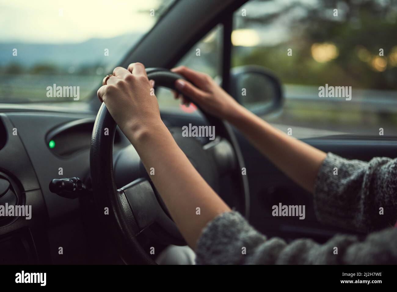 Hände am Lenkrad. Ausgeschnittene Aufnahme einer unkenntlichen Frau, die ihr Auto fährt. Stockfoto