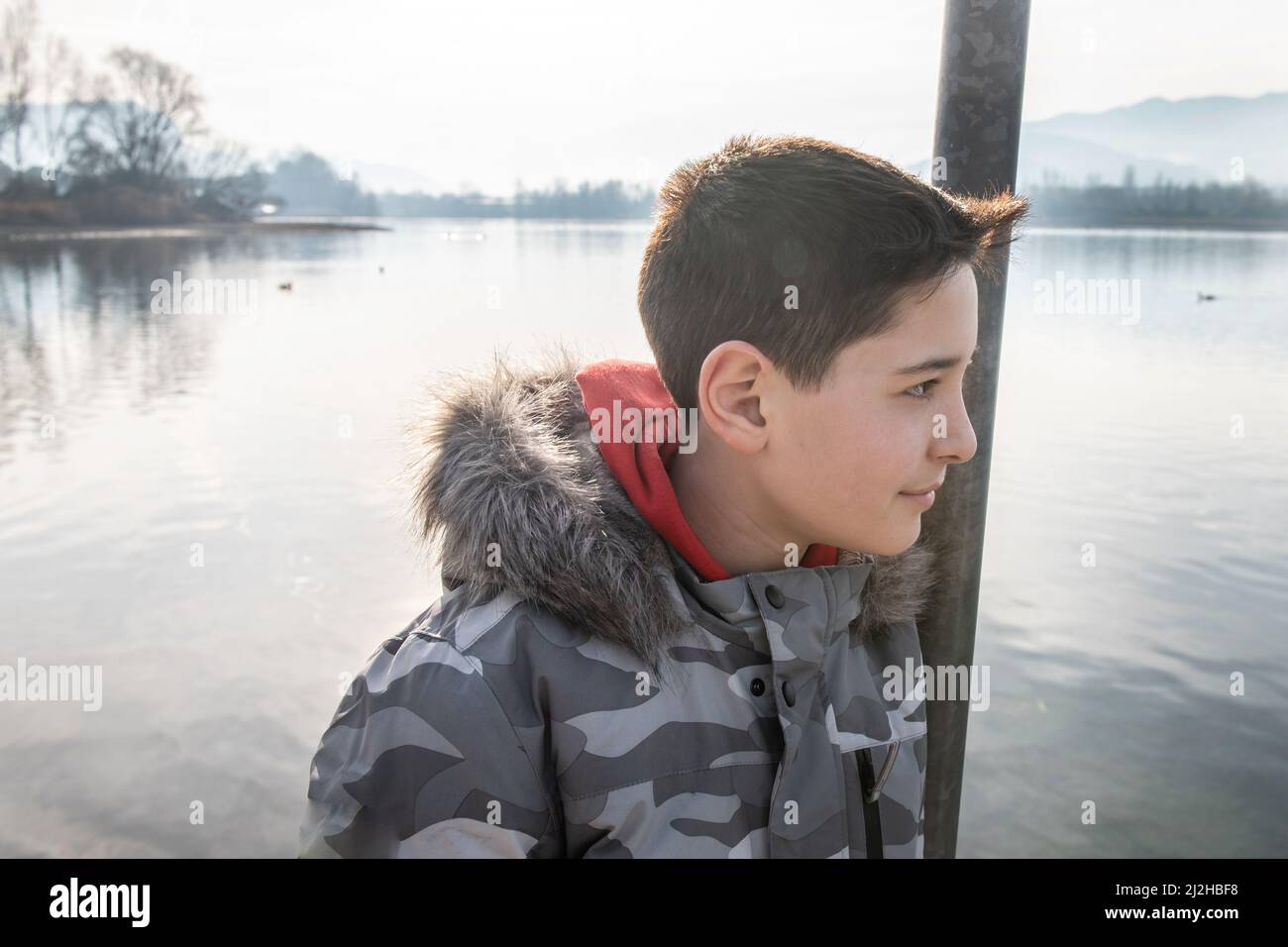 Italien, lächelnder Junge, am ruhigen See Stockfoto