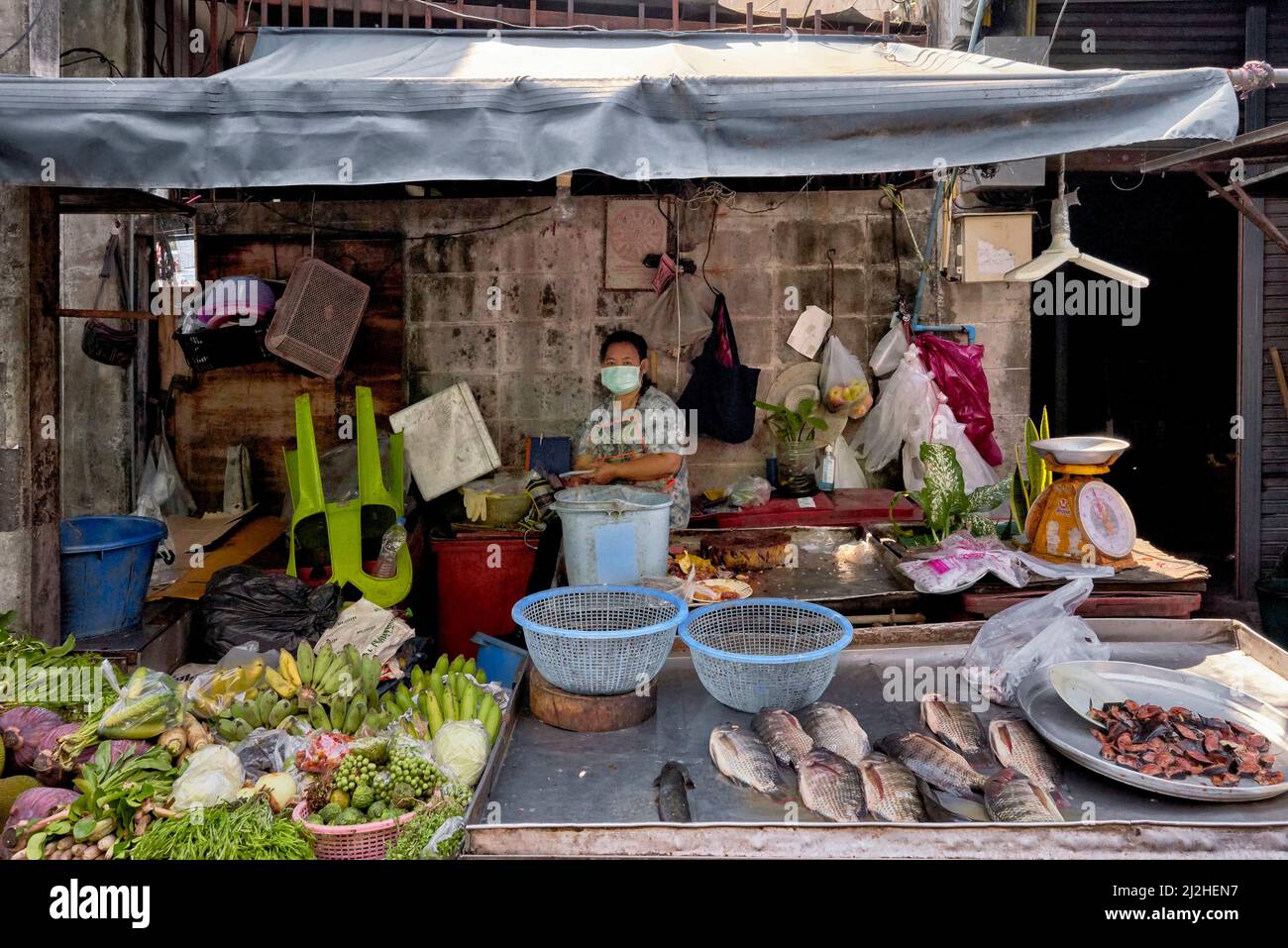 Thailands Marktverkäufer verkauft eine Auswahl an Lebensmitteln mit Fisch, Obst und Gemüse auf dem Display. Südostasien Stockfoto