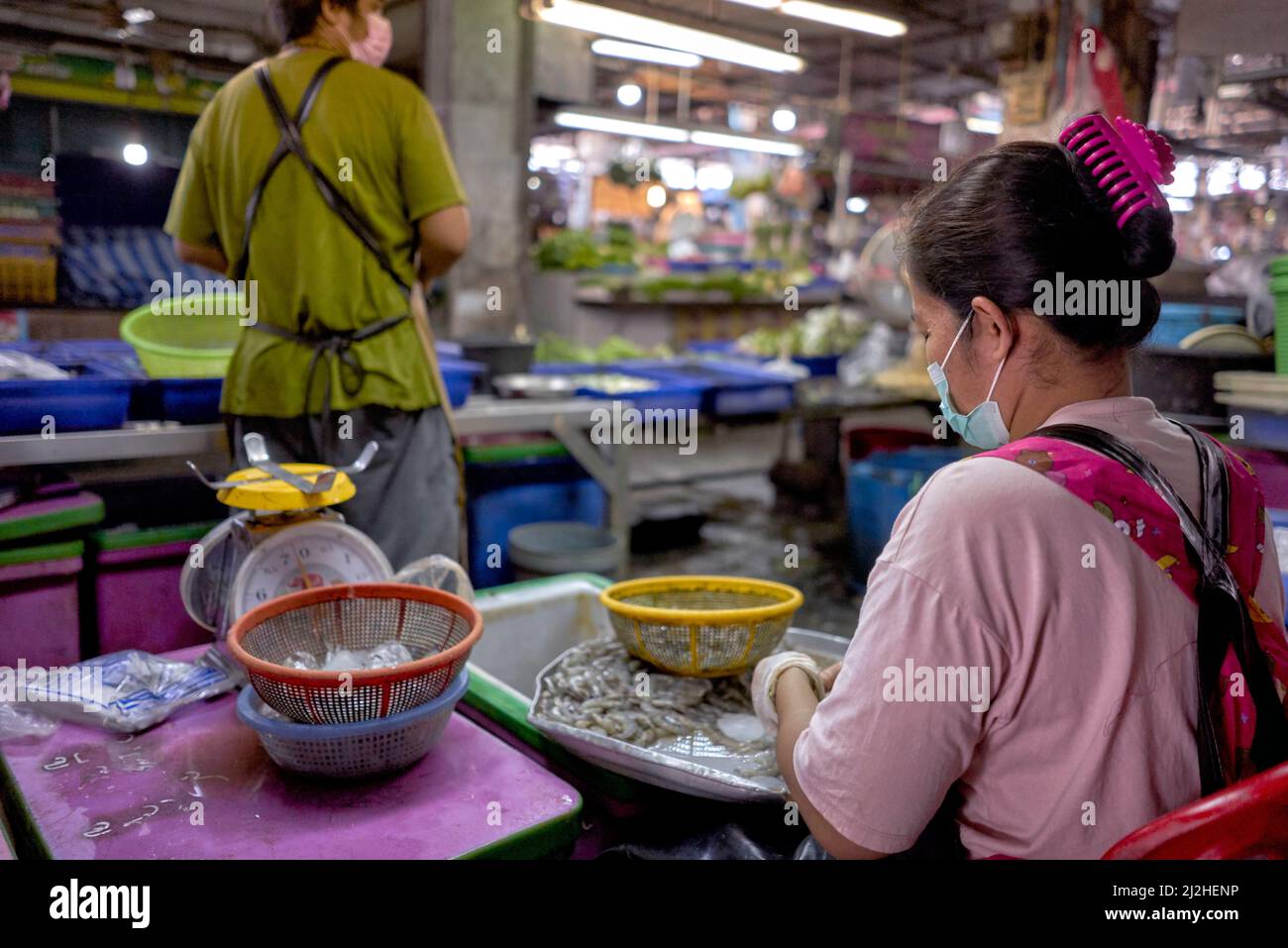 Ehemann und Ehefrau arbeiten zusammen auf dem thailändischen Fischmarkt und bereiten und verkaufen kleinen Flussminnowfisch, Clupeichthys aesarnensis Stockfoto