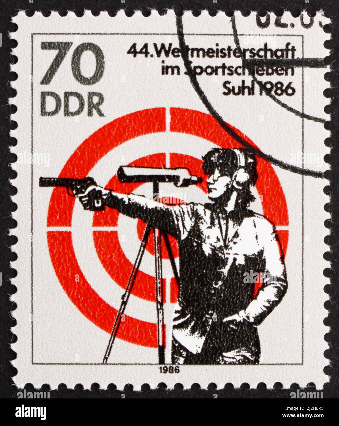 DDR - CIRCA 1986: Ein in der DDR gedruckter Stempel zeigt, wie eine Frau mit Handfeuerwaffe schießt, 44. World Sports Shooting Championships, Suhl, circa 1986 Stockfoto