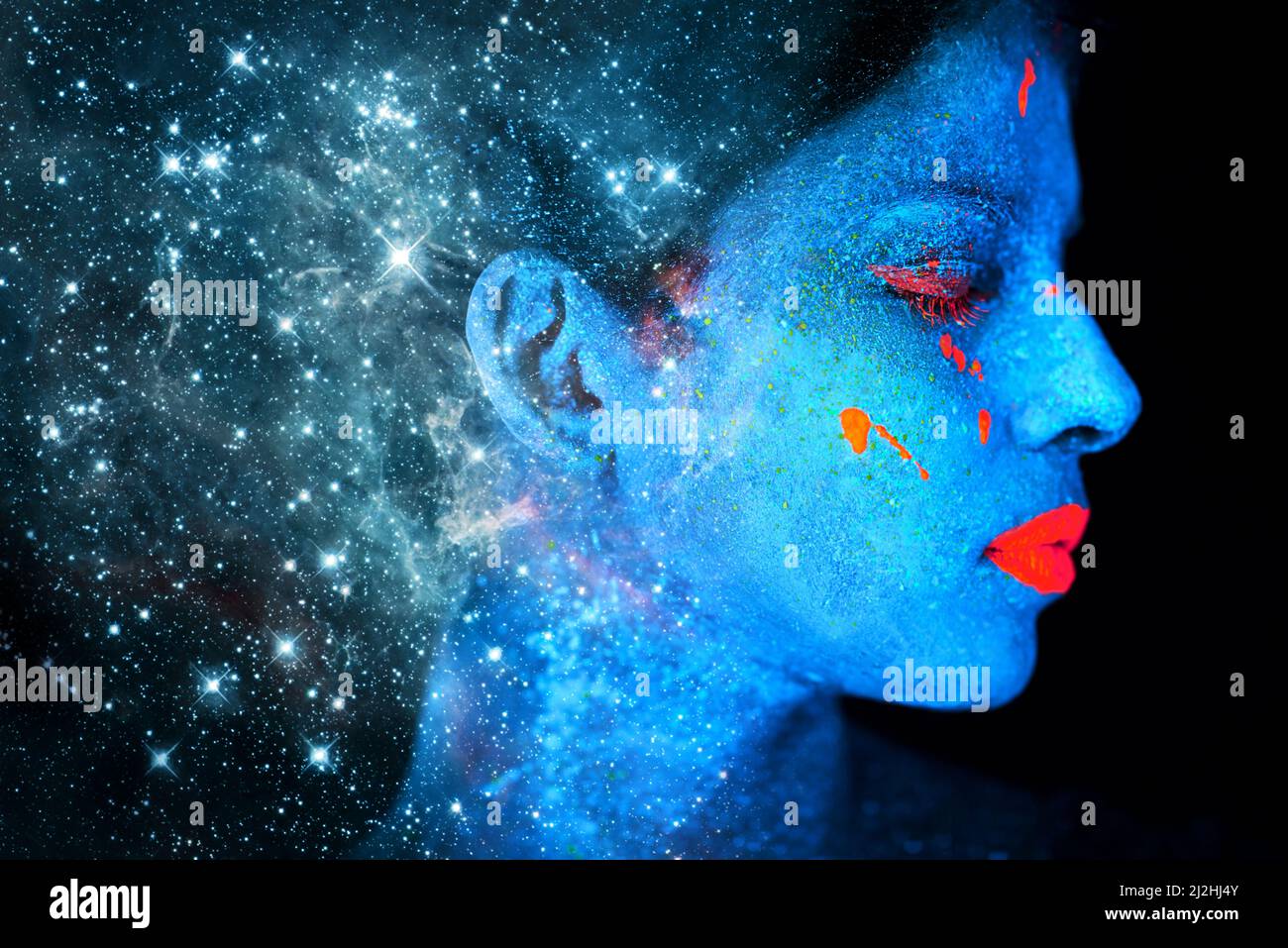 Himmlische Schönheit. Aufnahme einer jungen Frau, die mit Neonfarbe auf ihrem Gesicht posiert. Stockfoto