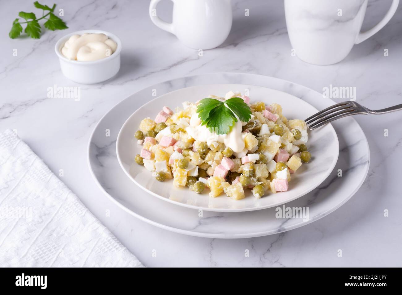 Russischer olivier-Salat mit Petersilie Stockfoto