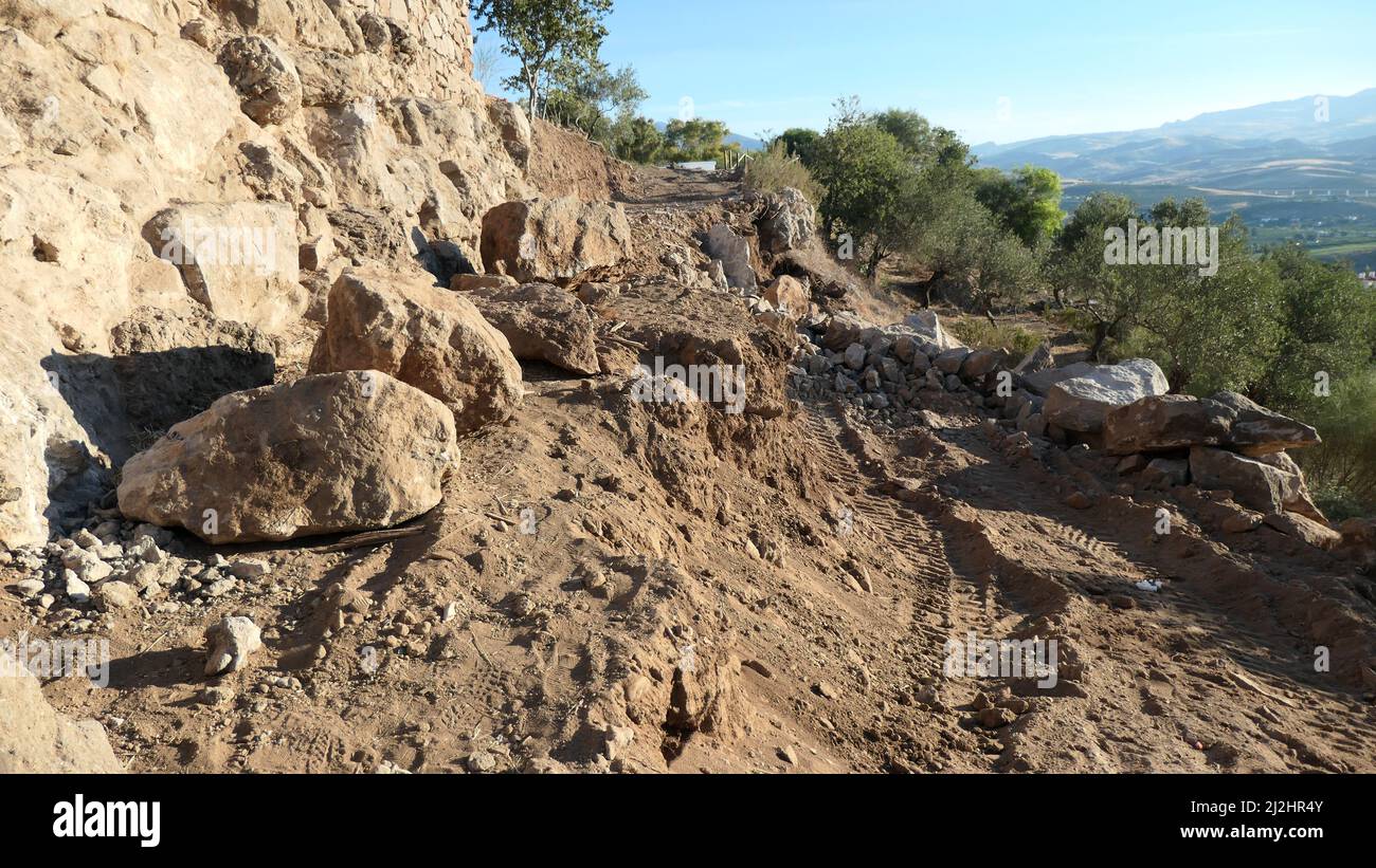 Felsen und Boden sowie Reifenspuren auf prekärer Straßenbaustelle im ländlichen Andalusien Stockfoto