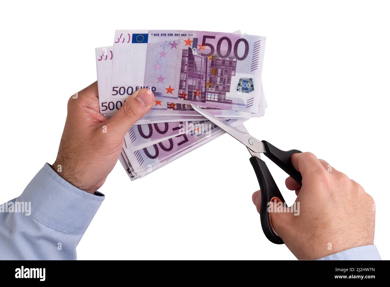 Mann schneidet einen Wad von 500-Euro-Banknoten mit einer Schere. Inflation und sinkende Geldpreise Stockfoto