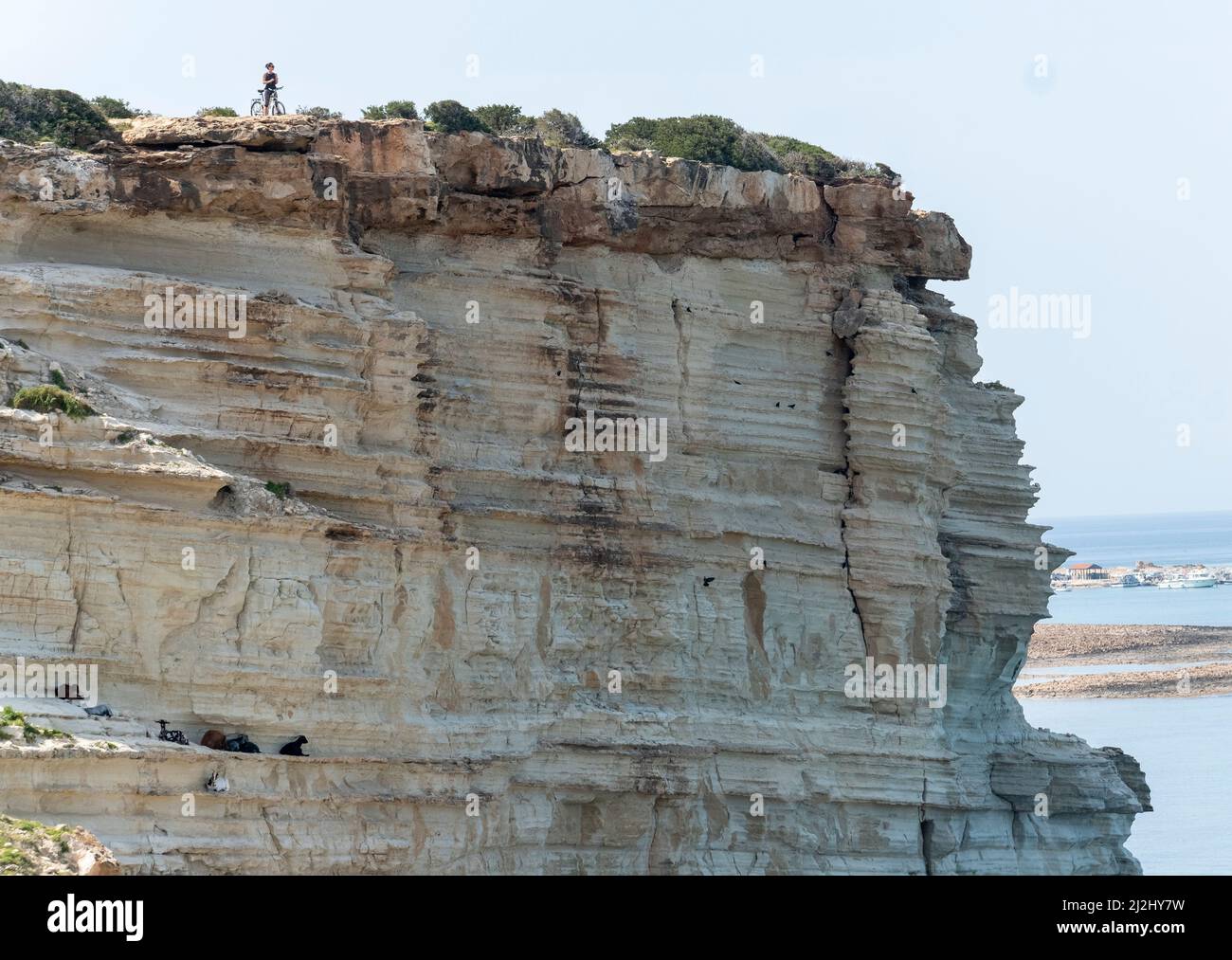 Von der Klippe der Avakas Bay im Akamas Peninsula National Park, Republik Zypern, blickt ein einmunder Radfahrer über das Meer. Stockfoto