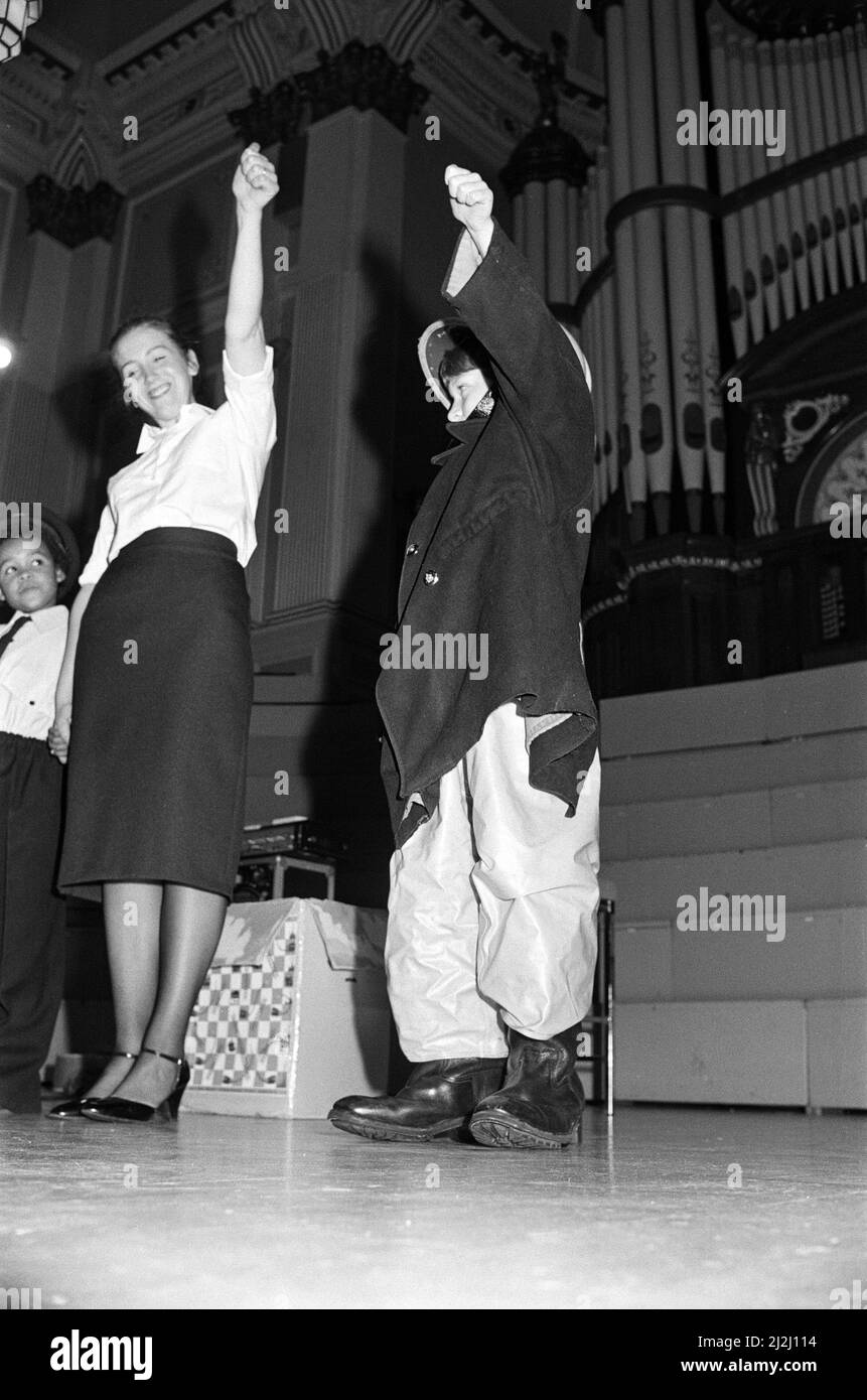 Der singende Feuerwehrmann Graham Walker gab heute im Huddersfield Town Hall hunderten von Schulkindern eine Feuerschutzausbildung der anderen Art. Graham erzählte Geschichten und sang über die Gefahren des Spielens mit Feuer. Jugendliche aus Säuglings- und Juniorschulen nahmen an der Show Teil, die bereits durch ganz West Yorkshire tourte. 9.. November 1987. Stockfoto