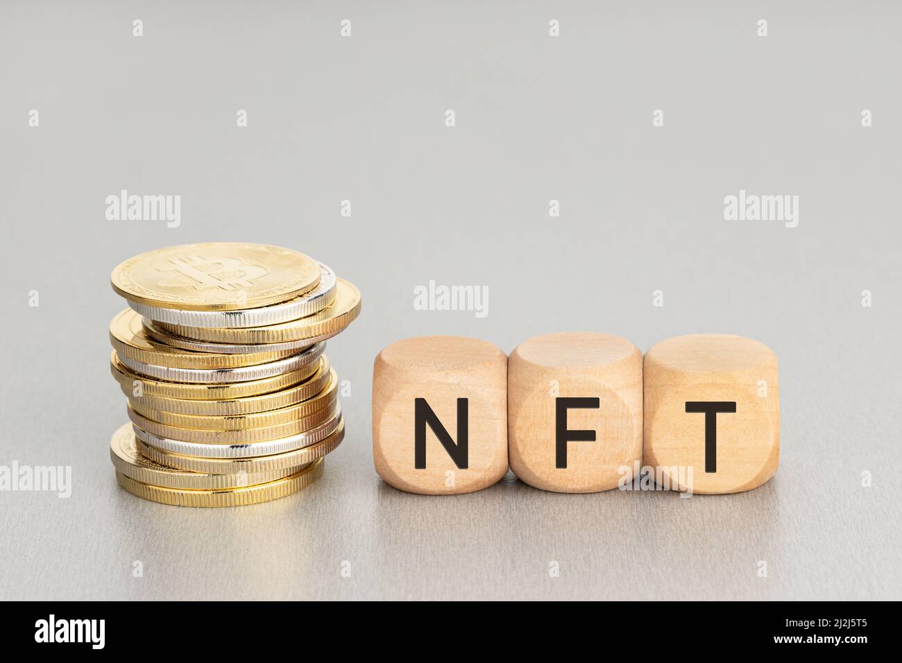 NFT-Konzept. Gestapelte Krypto-Münzen und Holzblöcke mit Text. Speicherplatz kopieren Stockfoto