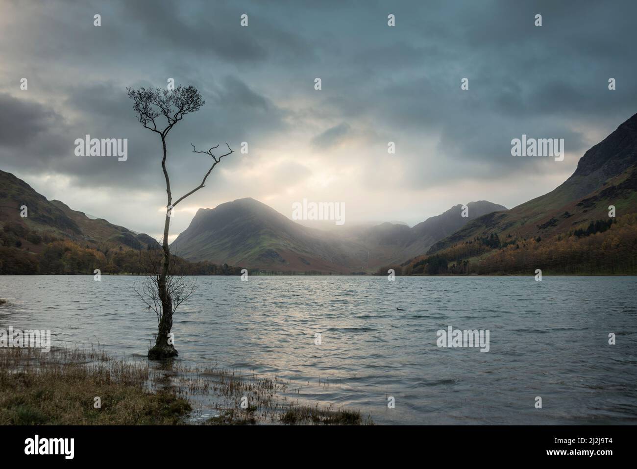 Atemberaubendes Landschaftsbild von Buttermere im Lake District bei Sonnenaufgang im Herbst mit dramatischem stürmischen Himmel Stockfoto