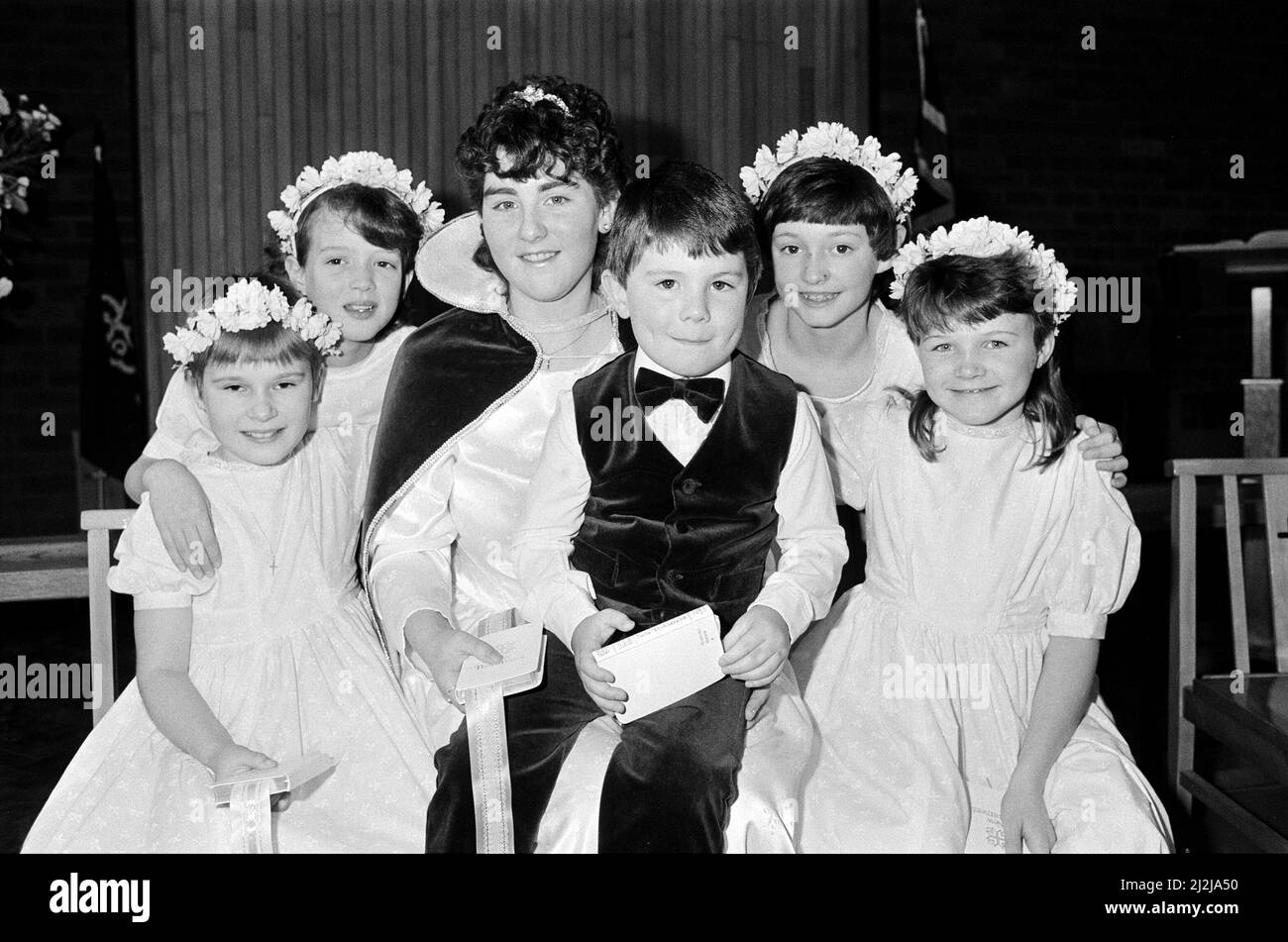 Das Chormädchen Debbie Fox ist die neue Sonntagsschulkönigin in der St. Andrew's Methodist Church, Mirfield. Debbie 16, die mit dem Jugendchor der Kirche singt, wird mit den Anwesenden Marie Robb, Michelle Pickering, Stephanie Guck und Claire Whitehead und dem Pagenjungen Joseph Pollard abgebildet. 8.. Februar 1987. Stockfoto