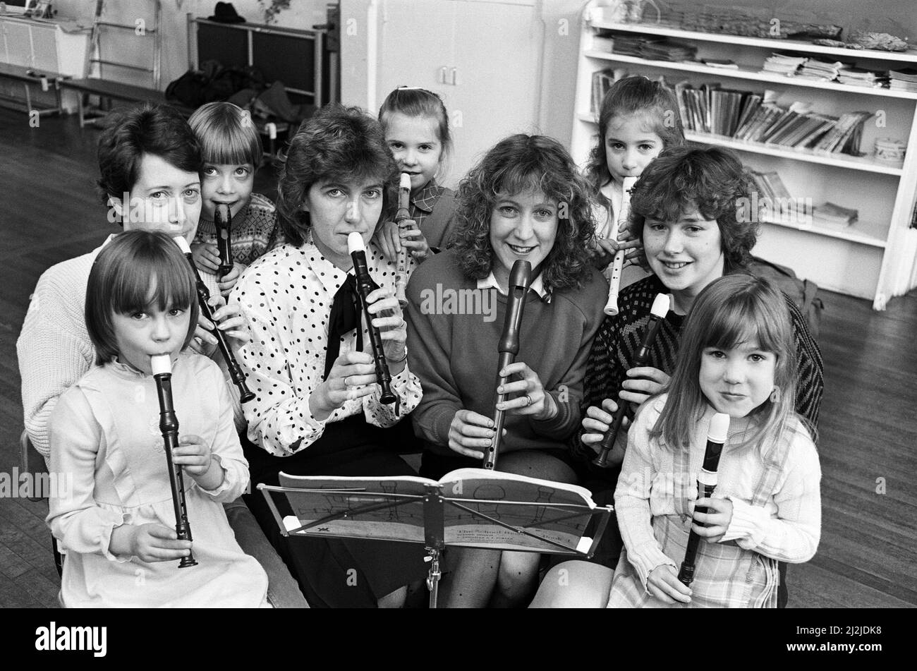 Diese Mirfield-Mütter haben sich an der Upper Hopton First School auf die Grundlagen zurückgegriffen. Sie haben sich ihren Kindern im Alter von sieben bis neun Jahren zum Blockflötenunterricht angeschlossen. „Mütter sagten, sie wollten ihren Kindern helfen können, und alles begann damit“, sagte die Schulleiterin Nolen Hobson. Die Lehrerin Frau Pamela Hall gab ihnen Vorstunden, um sie auf den Stand zu bringen, und jetzt nehmen sie regelmäßig an der Klasse Teil. Die sechs Mütter debütierten bei einem Schuldienst am Muttertag. 8.. April 1987. Stockfoto