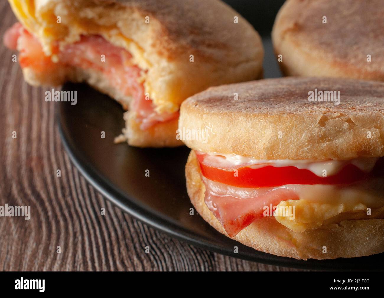Englischer Muffin mit Eierschinken, Tomate, Mayo und Käse, Makrofotografie. Stockfoto