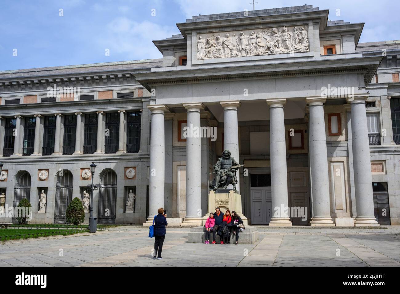 Besucher, die ein Familienfoto mit einer Statue des Künstlers Diego Velázquez am Eingang des Prado Museums in Madrid, Spanien, machen. Stockfoto