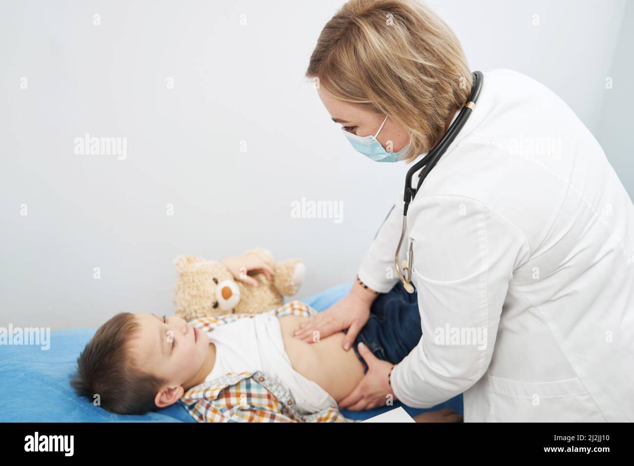 Kinderärztin, die den Abdomen des Kindes in der Klinik untersucht Stockfoto