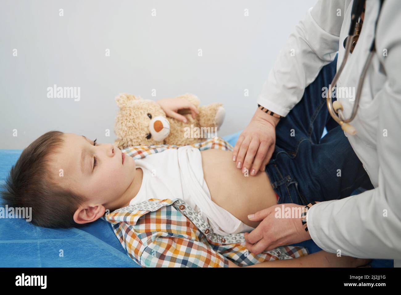 Arzt untersucht Kind und tun Abdominalpalpation Stockfoto