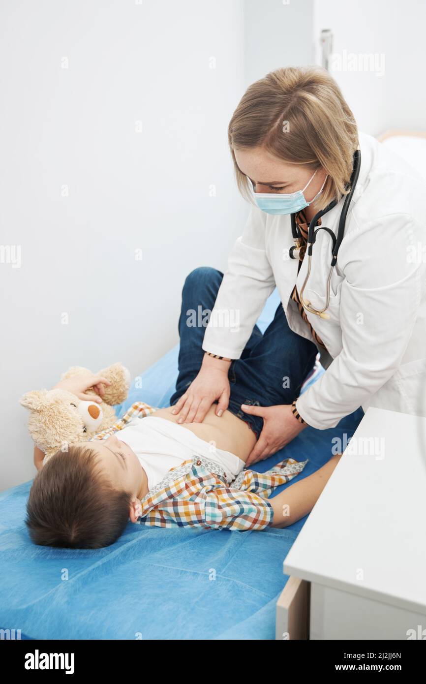 Ärztin, die den Abdomen eines Kindes in der Kinderklinik untersucht Stockfoto