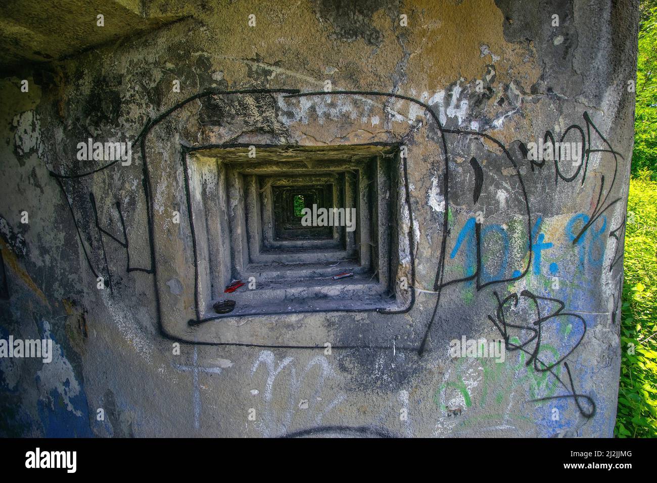 Eine schöne Nahaufnahme eines alten Steinlochs in einer Bunkerwand mit Gemälden Stockfoto