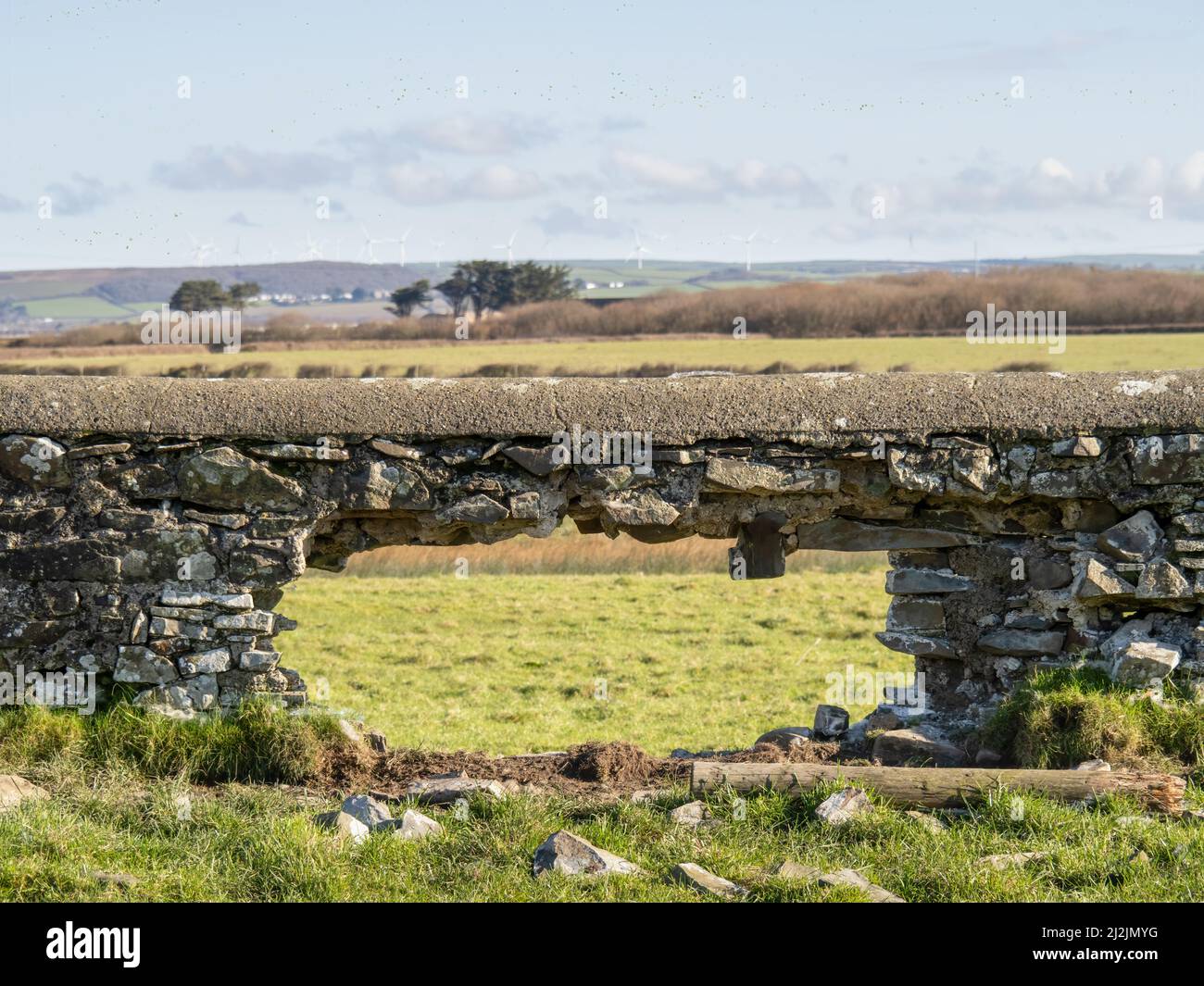 Loch in einer alten Steinmauer, ländlicher Hintergrund. Stockfoto