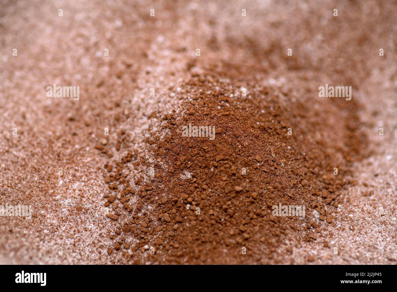 Hintergrund aus pulverförmigem Kakao und mit ihm gemischtem Zucker, selektive Schärfentiefe. Stockfoto