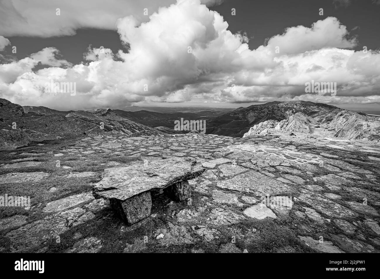 Felsige Landschaft mit einer Steinbank auf der Spitze des Hügels, schwarz-weiß Foto. Stockfoto