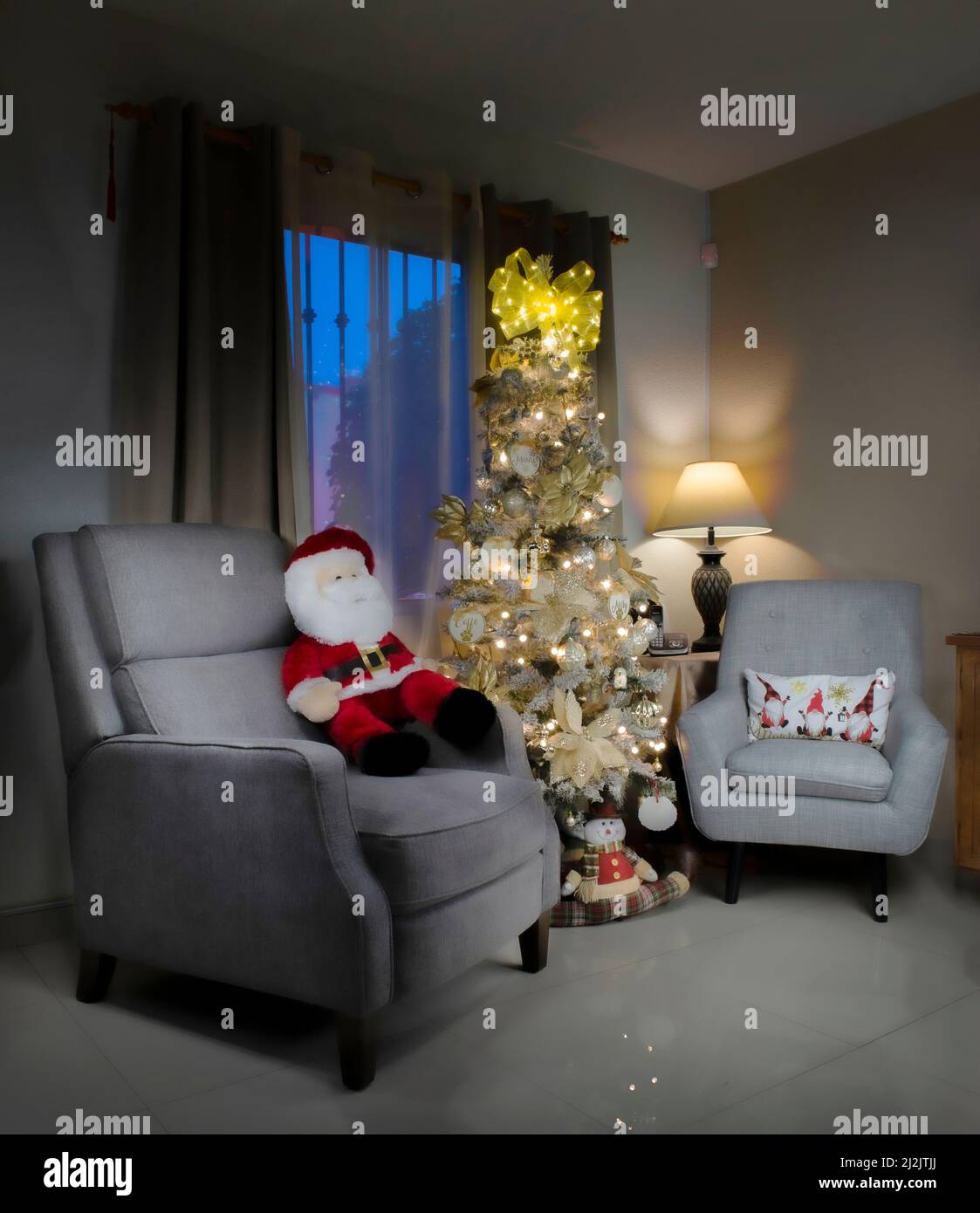 Weihnachtsdekoration in einem Wohnzimmer mit Fensterblick und einem weihnachtsbaum und einem warmen Licht von einer Lampe in der Ecke und einem weihnachtsmann Stockfoto