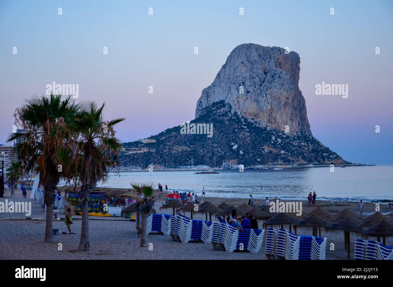 Blick über den Strand von Calpe auf den Penyal d'IFAC-Felsen im Mittelmeer im Abendlicht der Dämmerung Stockfoto