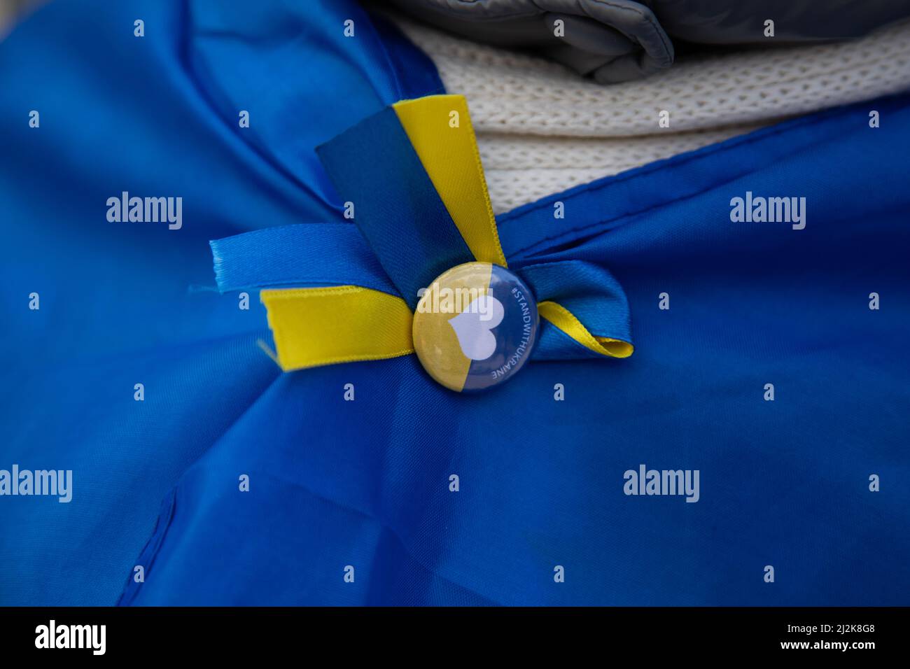 London, Großbritannien. 2. April 2022. Eine Frau trägt einen pi in ukrainischen Farben, um ihre Flagge zu sichern, während sich Menschen auf dem Trafalgar Square versammelt haben, um Solidarität mit der Ukraine zu zeigen und ein Ende des Krieges zu fordern. Quelle: Kiki Streitberger/Alamy Live News Stockfoto